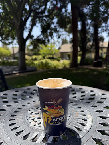 A cup of Zerame coffee on a metal patio table in the courtyard