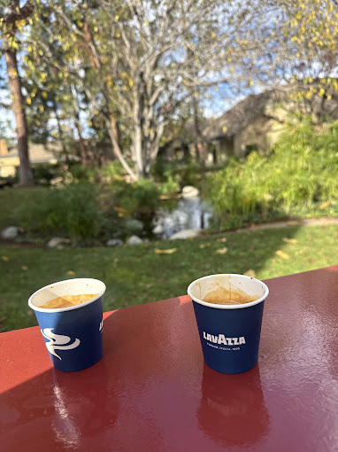 Two espresso cups resting on a red painted railing