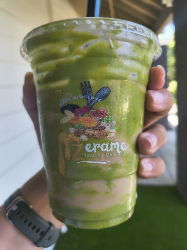 An iced matcha latte held up on the patio