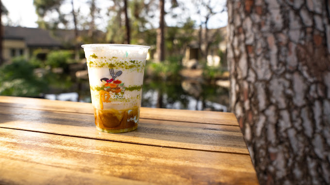 A layered pistachio parfait latte among the trees