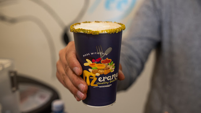 A Zerame cup with a dusted pistachio rim held up indoors